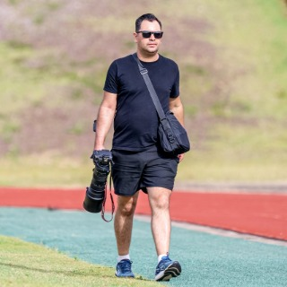 Bruno Francisco, fotógrafo do Arcanjo Fotos, com sua câmera em uma pista de atletismo